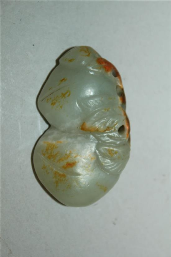 A Chinese celadon and russet jade carving of two peaches, 19th / 20th century, 6cm